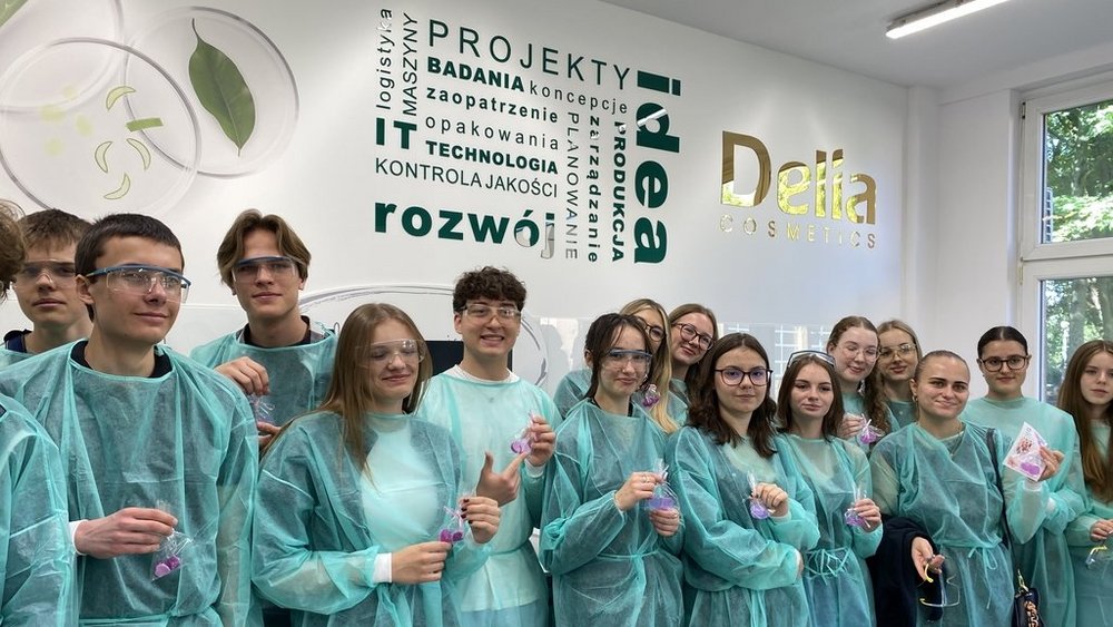 grupa młodych ludzi w ochronnych fartuchach w laboratorium chemicznym